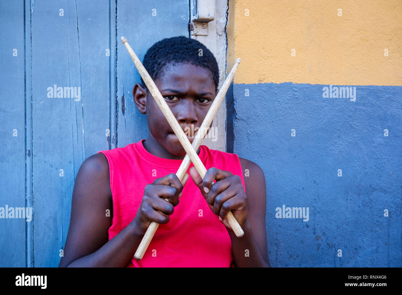 Portrait of young African-American street drummer boy looking at camera holding drumsticks on Bourbon Street, New Orleans French Quarter New Orleans Stock Photo