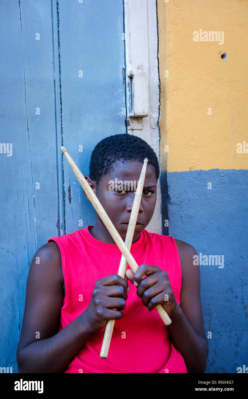 Portrait of young African-American street drummer boy looking at camera holding drumsticks on Bourbon Street, New Orleans French Quarter New Orleans Stock Photo