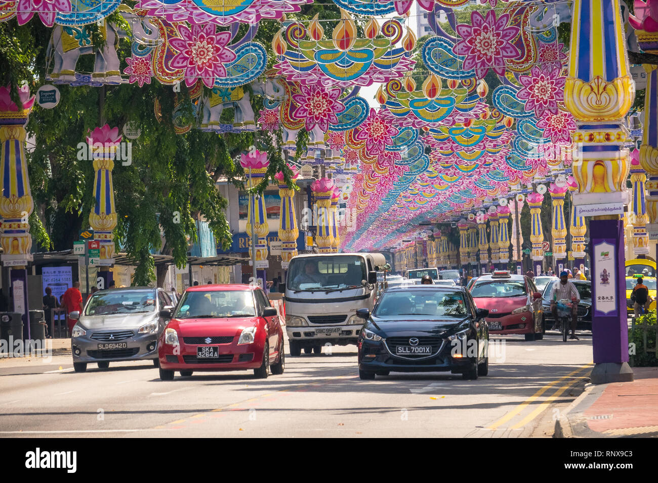 Deepavali Traffic - Cars and Vans driving under pink banners for this colorful Singapore Festival - Little India Stock Photo