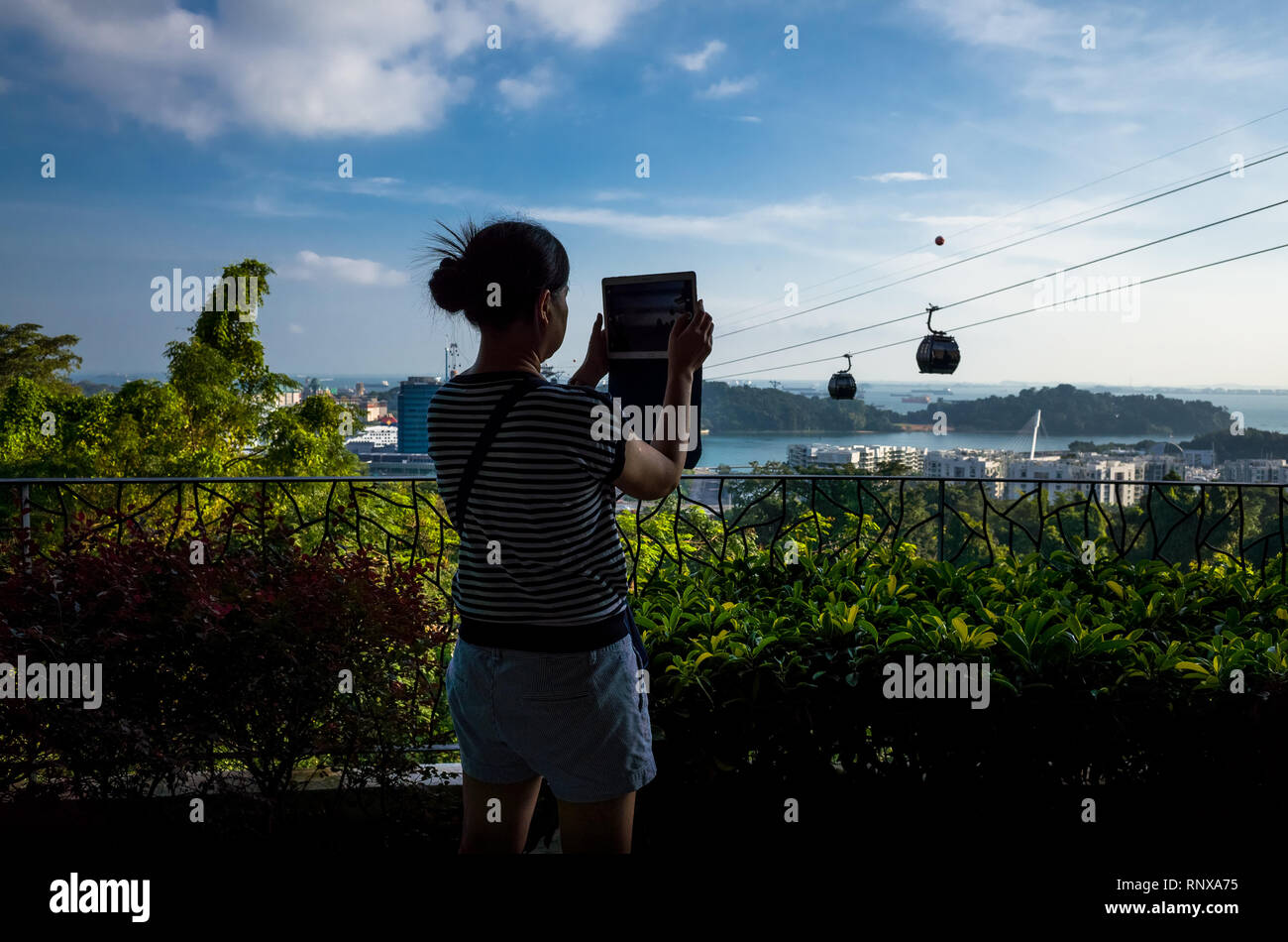 Tourist woman taking photo of Cable Cars at vista Mount Faber Park