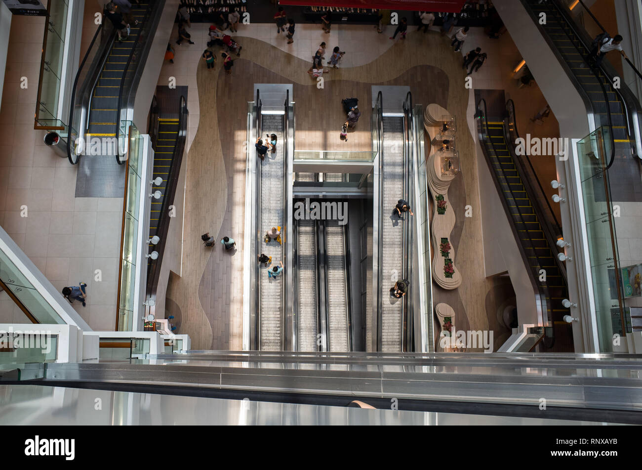 Tourist Crowd and Shoppers Riding Escalators at Plaza Singapura Mall, Singapore Stock Photo