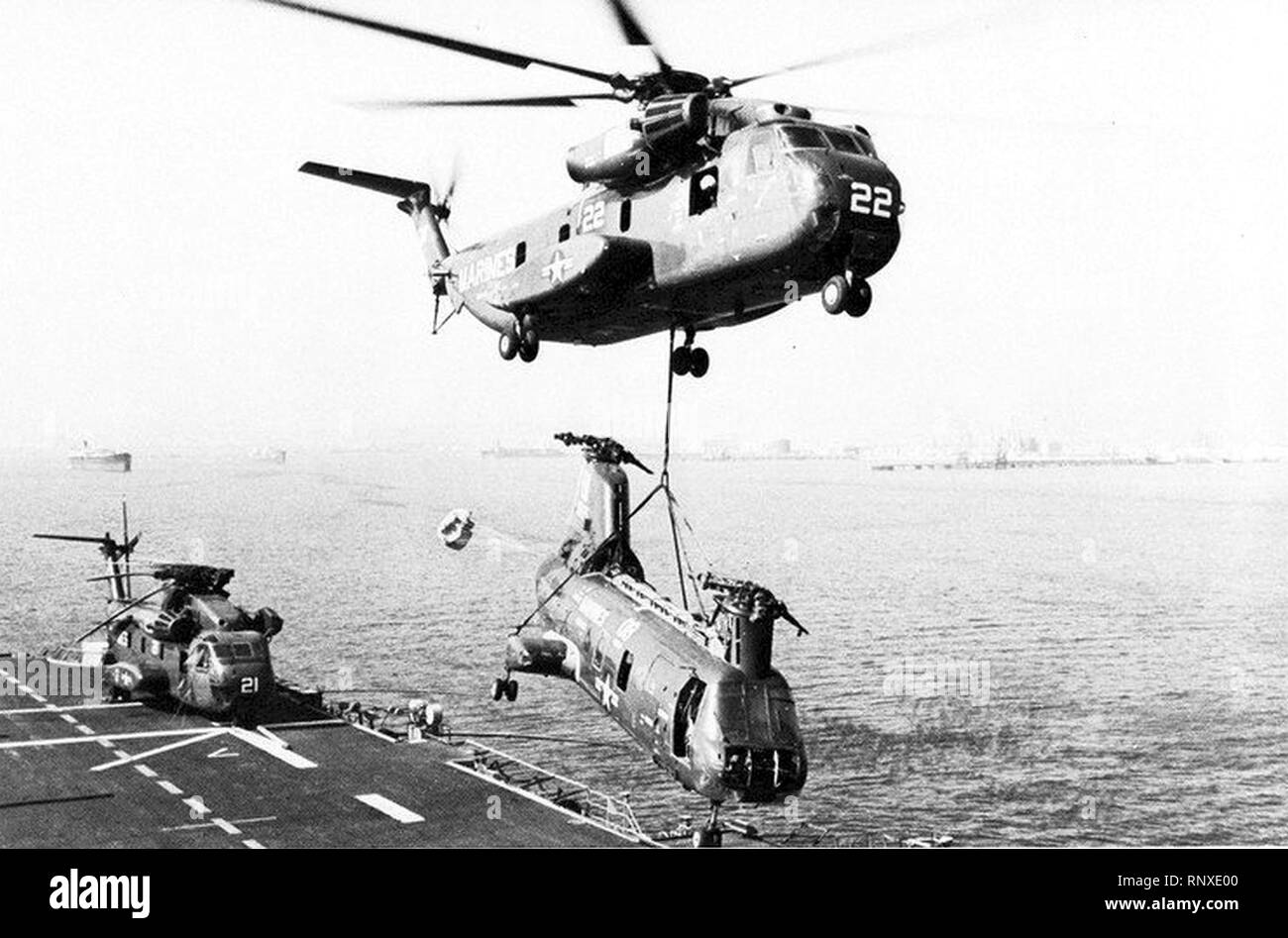 CH-53 lifts CH-46 from USS Inchon (LPH-12) in 1977. Stock Photo