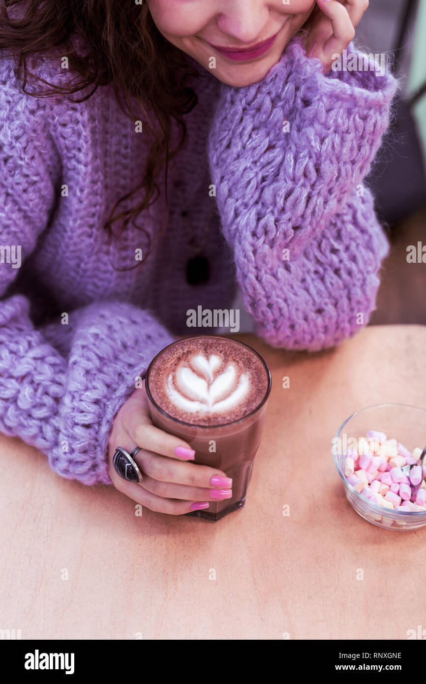 Pretty smiling lady in oversize violet sweater Stock Photo