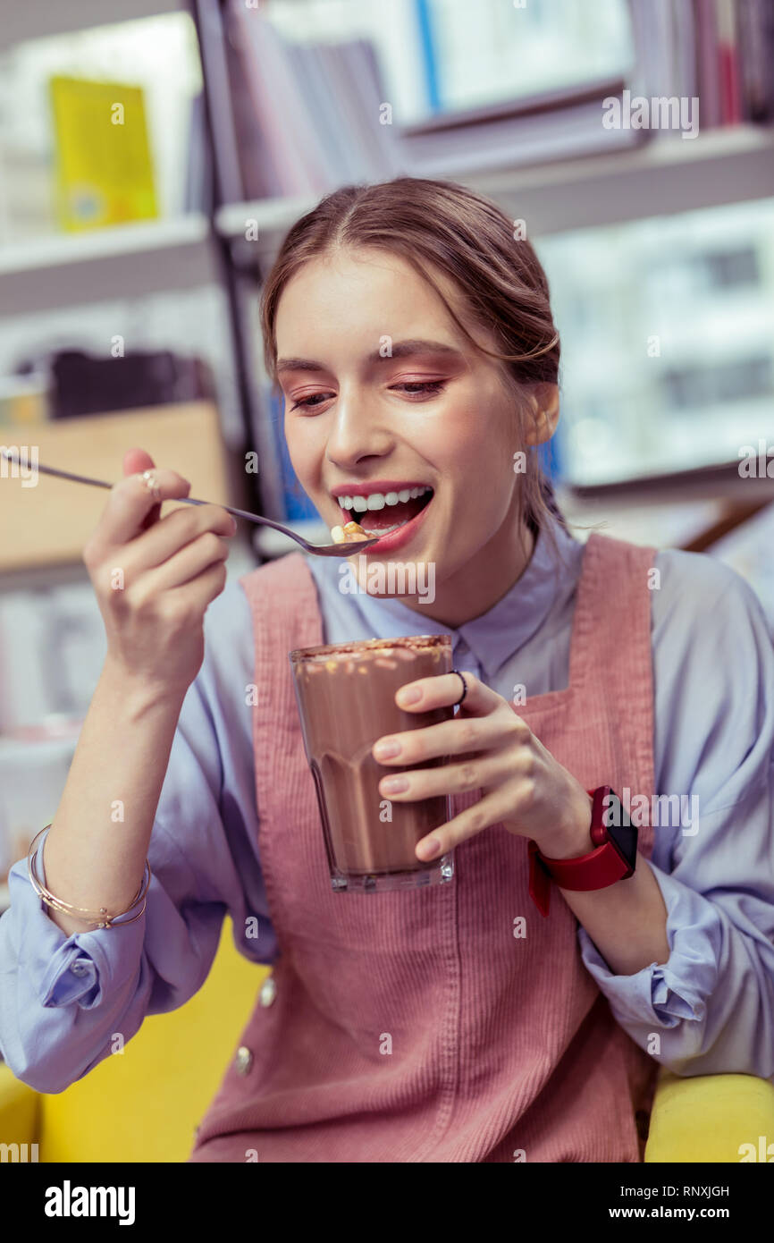 Smiling girl with strong white teeth trying marshmallows Stock Photo