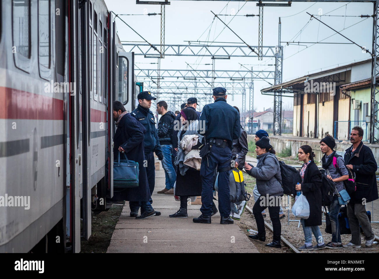 SID, SERBIA - NOVEMBER 14, 2015: Croatian police officers checking refugees, boarding a train to cross the Croatia Serbia border, at the Sid train sta Stock Photo