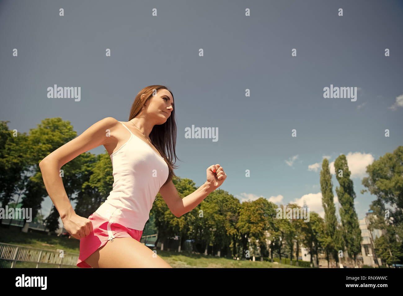 Woman running on arena track. Girl sunny outdoor on blue sky. Coach or  trainer at workout. Runner on competition and future success. Sport and  healthy fitness Stock Photo - Alamy