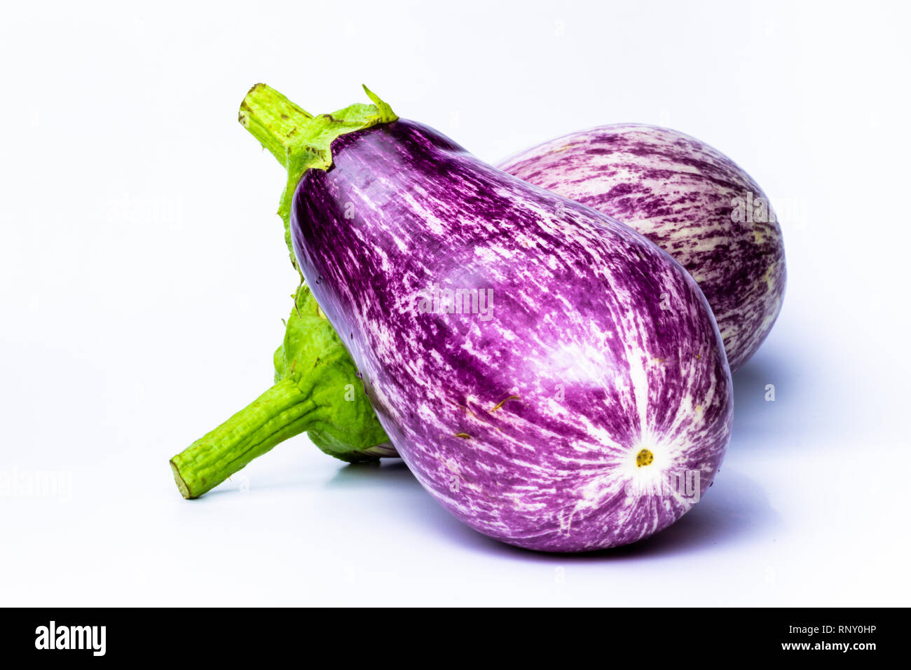 Two white eggplants isolated on white background. Horizontal view Vegetable violet and white with the green cape. Vegan organic food. Stock Photo
