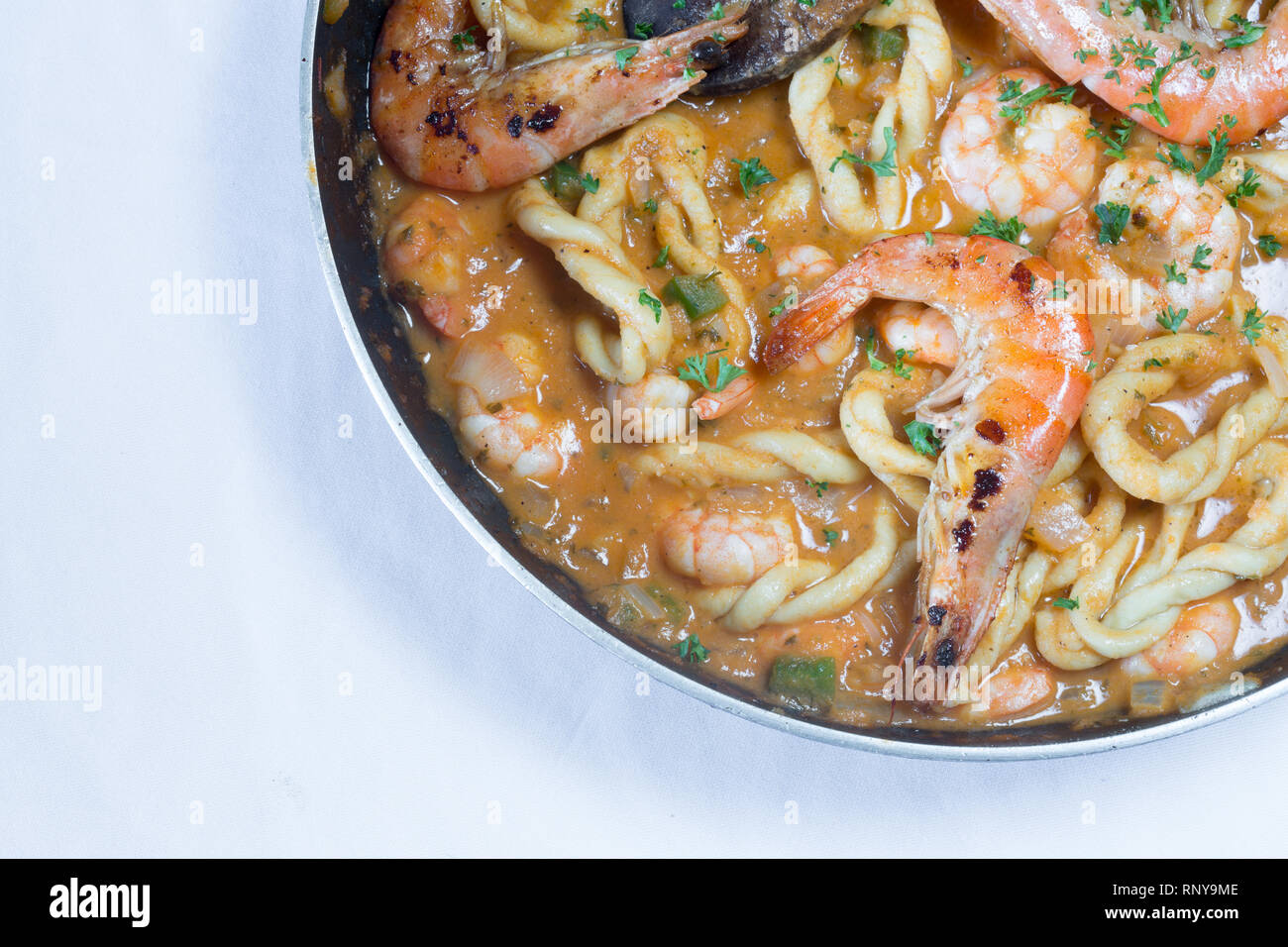 Handmade Sardinian specialty pasta, Lorighittas, with Prawns and seafood sauce in the pan ready to serve. Stock Photo