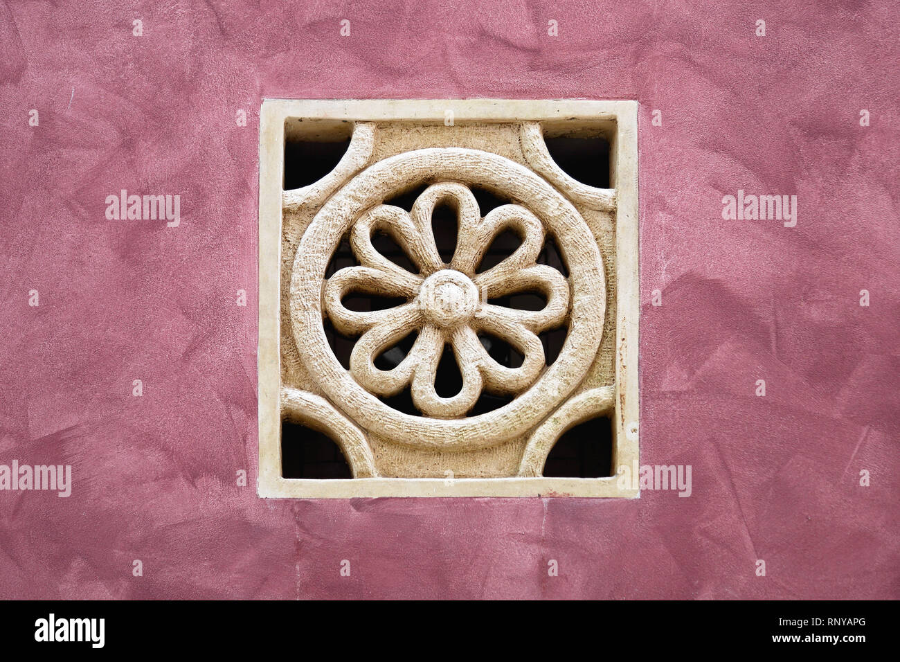 Stone flower at purple wall architectural detail Stock Photo - Alamy