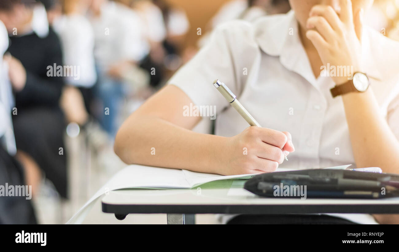 School student's taking exam, thinking hard, writing answer in classroom for educational university admission test  and world literacy day concept Stock Photo