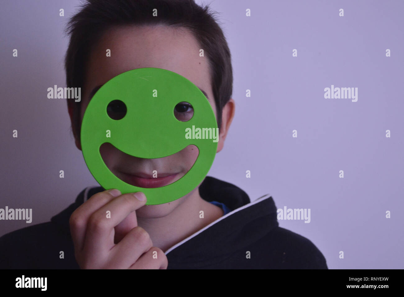 Boy covering face with smiley Stock Photo