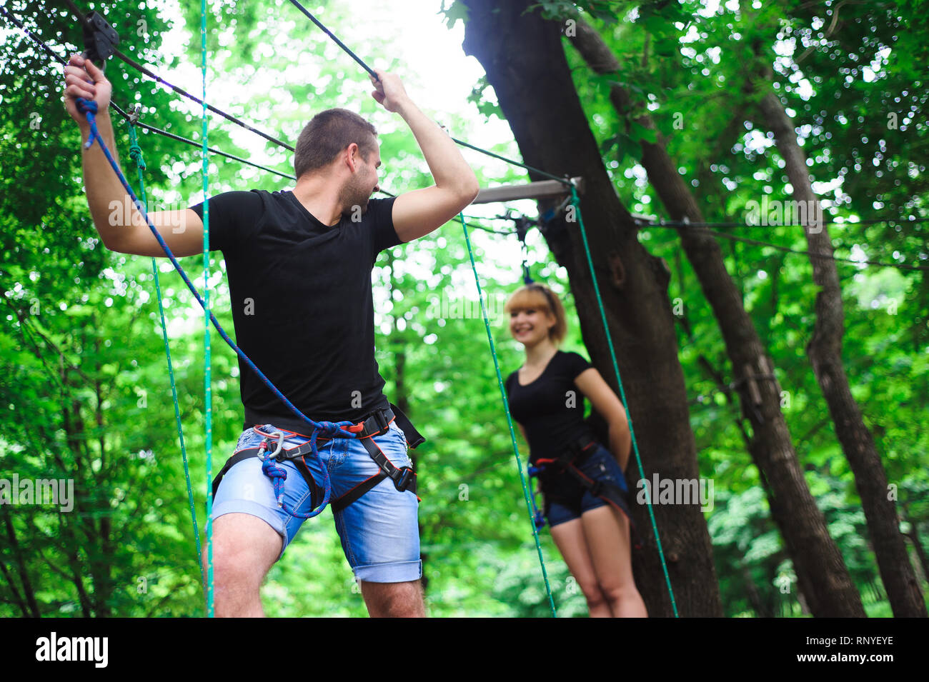 People Using Toe Rope Hiking in the rope park two young people Stock Photo - Alamy