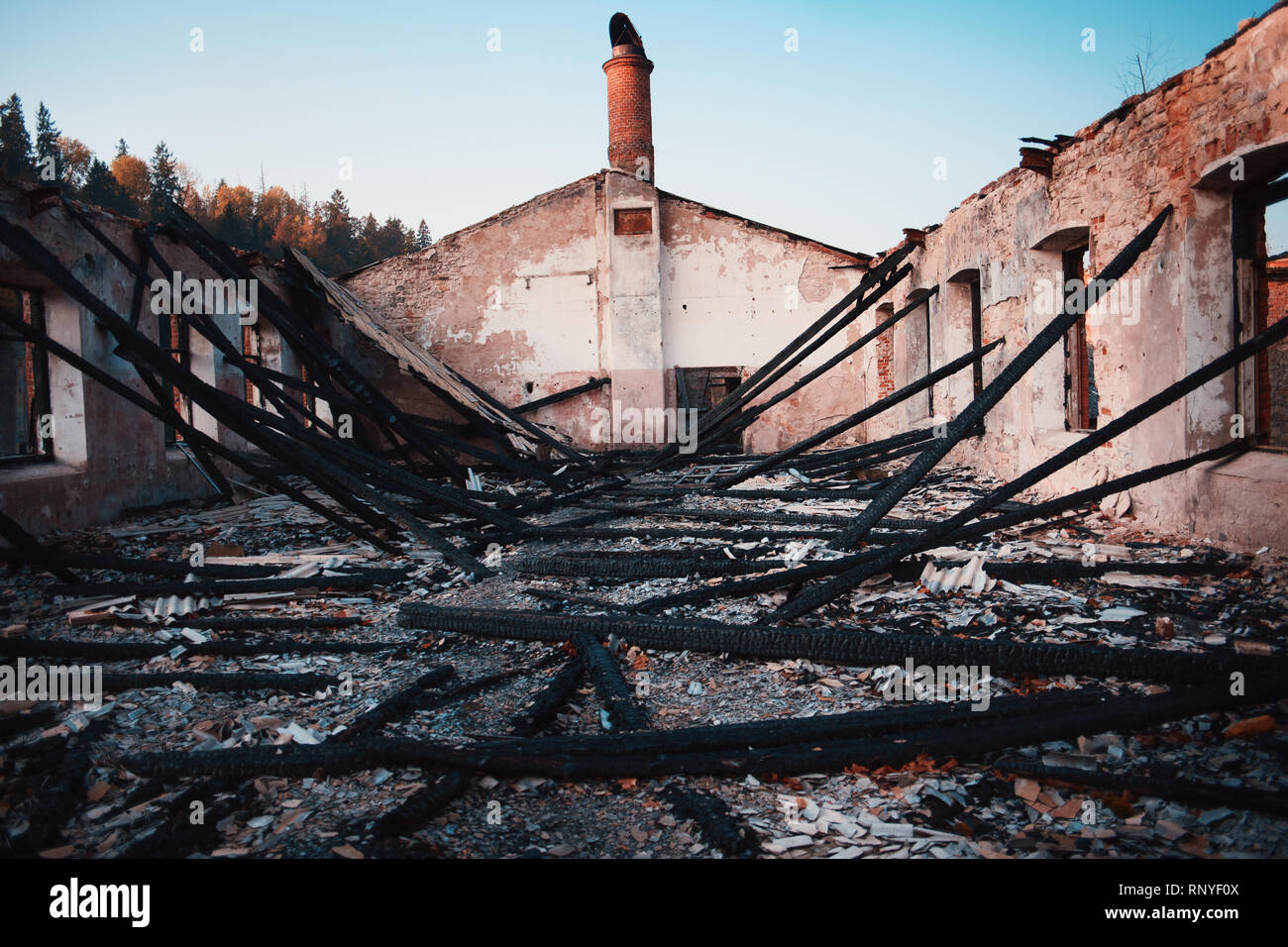 Burnt wooden house. House after the fire. Burned brick house with burnt roof inside view Stock Photo