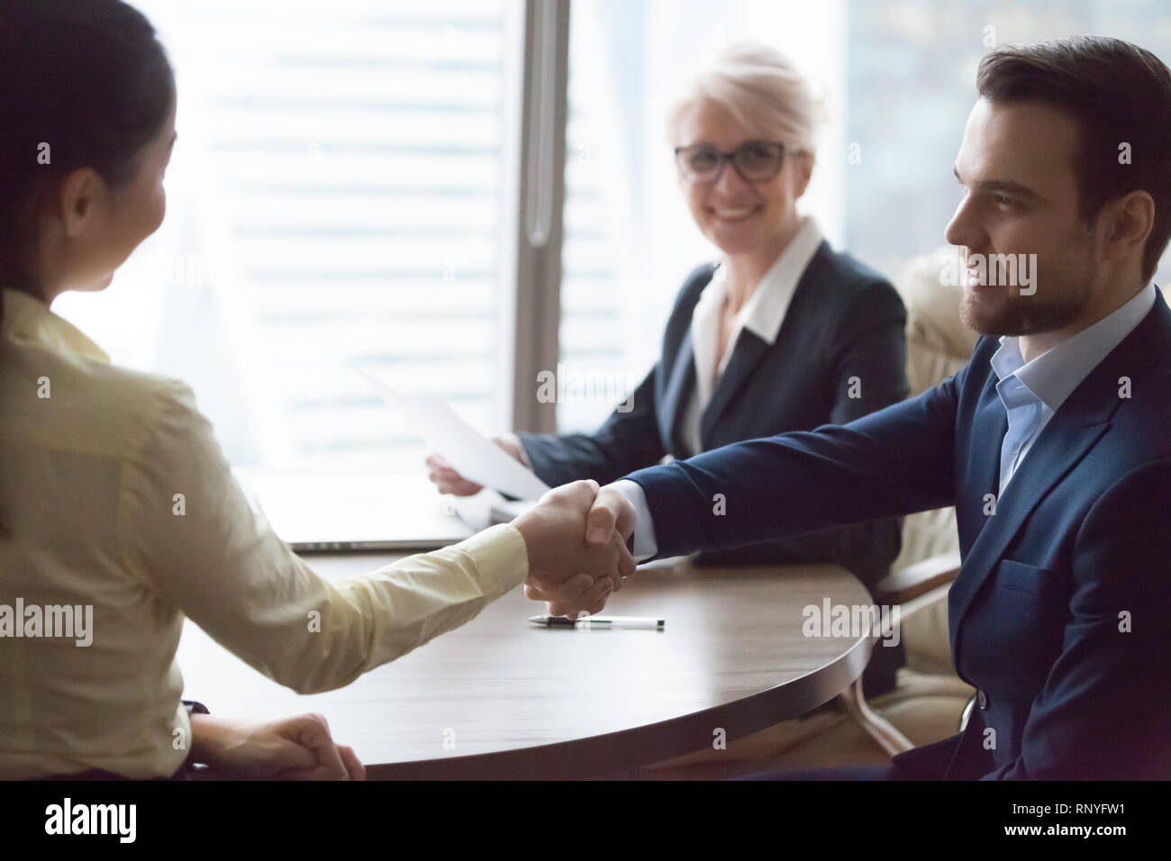 Happy hr manager hiring successful candidate at job interview Stock Photo