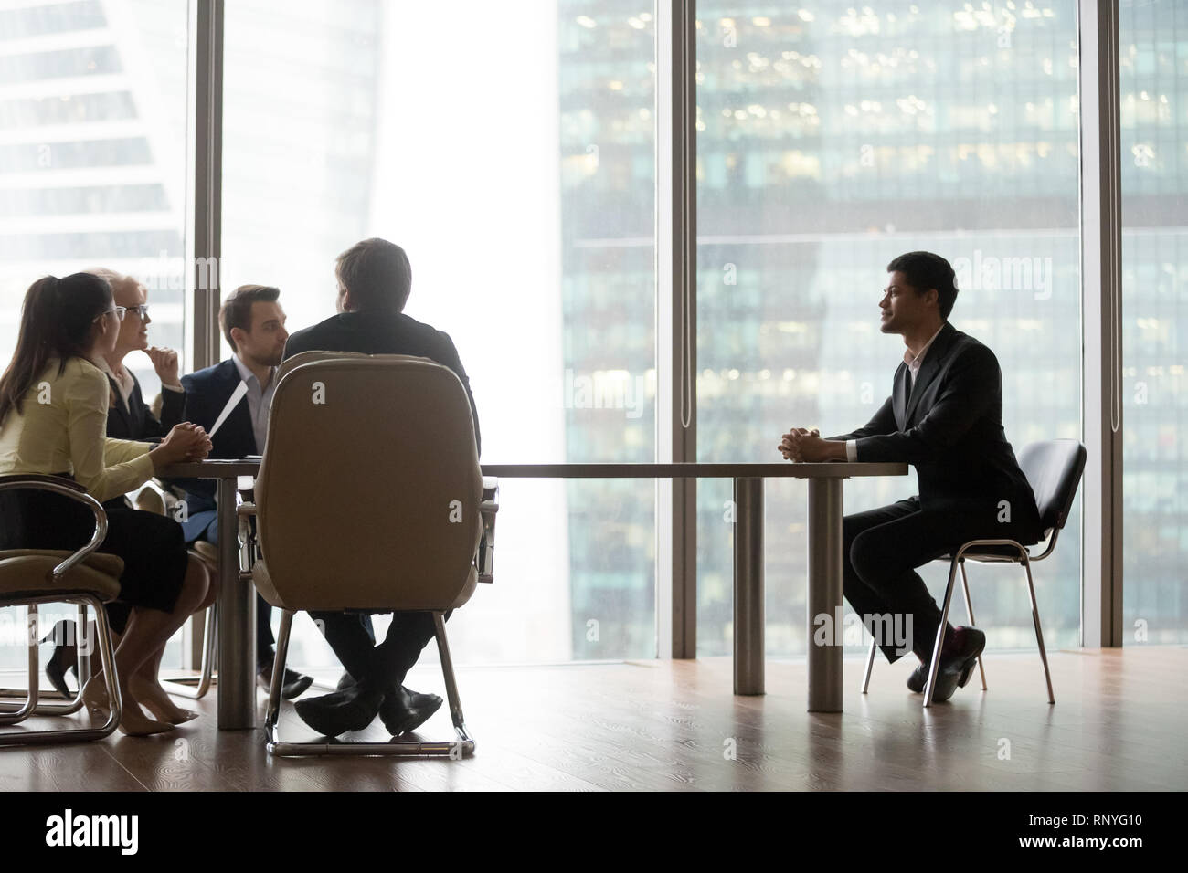 Hr team interviewing african candidate sitting at table in office Stock Photo