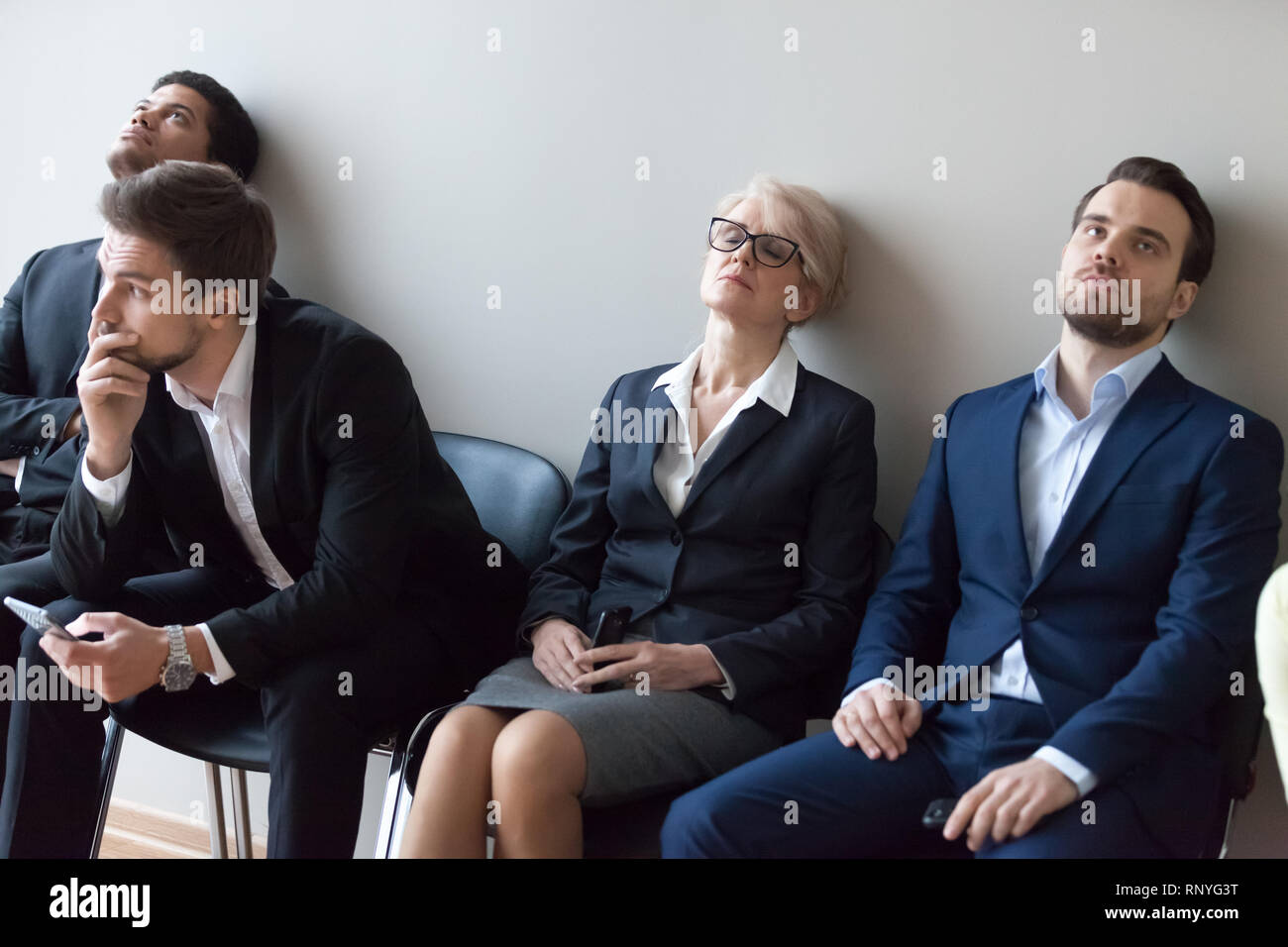 Diverse applicants getting bored in queue waiting for job interview Stock Photo
