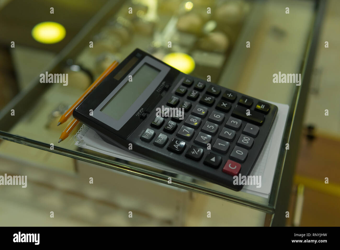Calculator on glass showcase closeup, business concept. Money saving,  calculate sale price, shop financial budget Stock Photo - Alamy