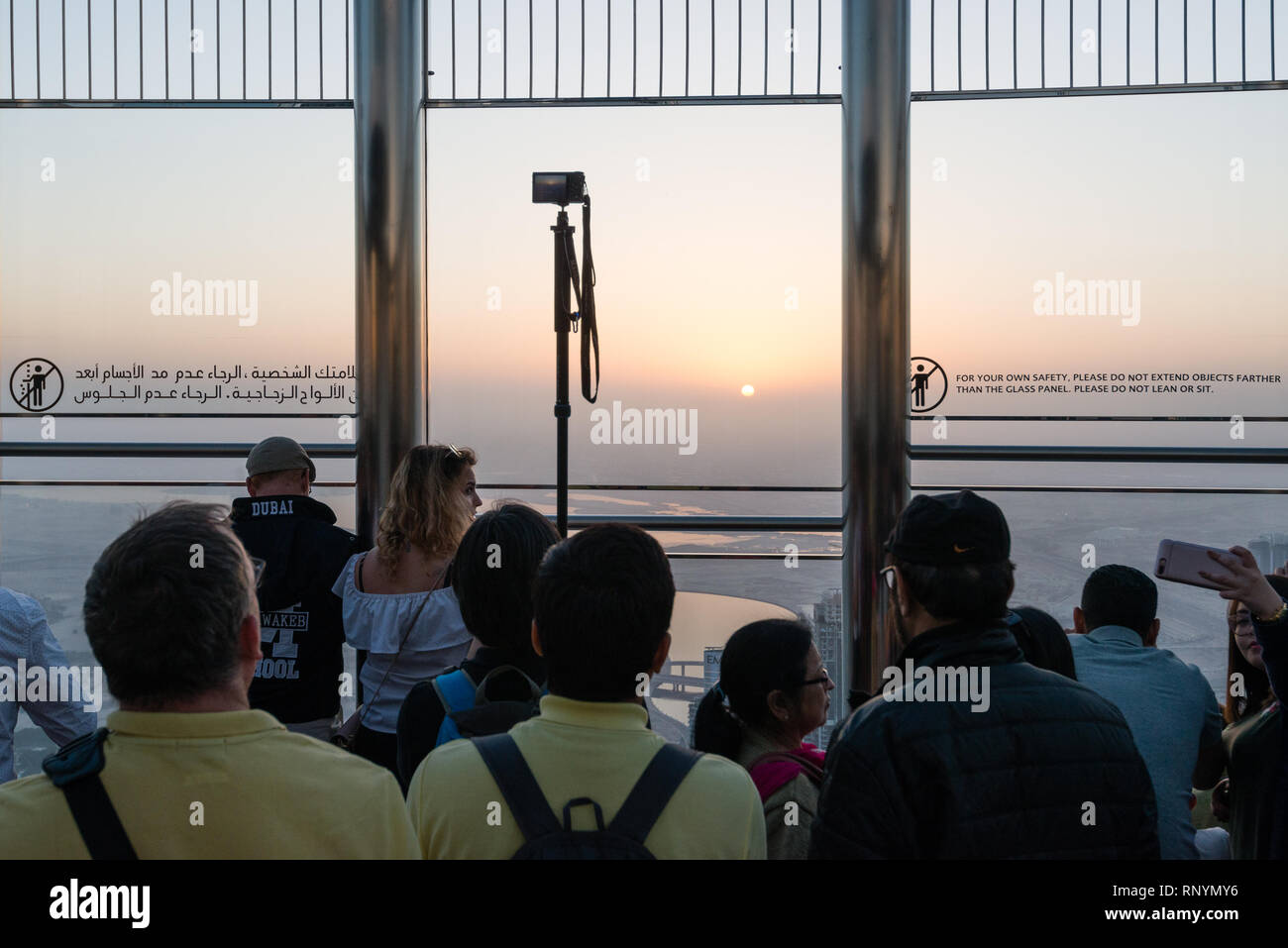 DUBAI, UAE - February 17, 2018: Tourists look at sunrise at the observation deck at the top of Burj Khalifa - highest building in the world, United Ar Stock Photo