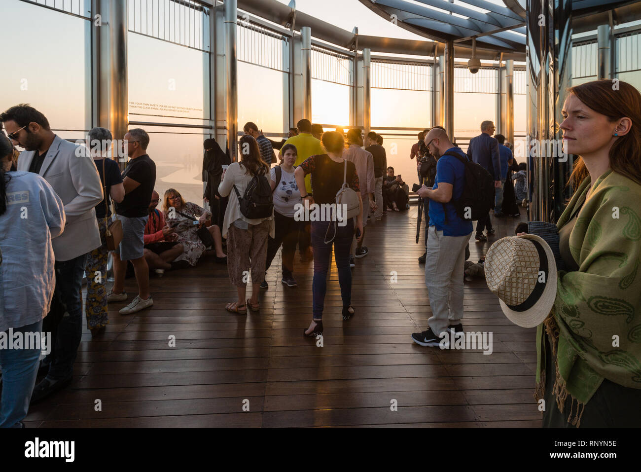 DUBAI, UAE - February 17, 2018: Tourists look at sunrise at the observation deck at the top of Burj Khalifa - highest building in the world, United Ar Stock Photo