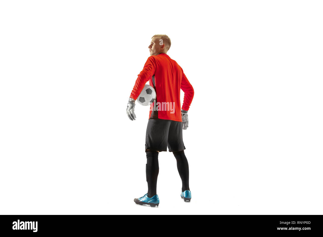 One male soccer player goalkeeper standing and holding ball. Silhouette isolated on white studio background Stock Photo