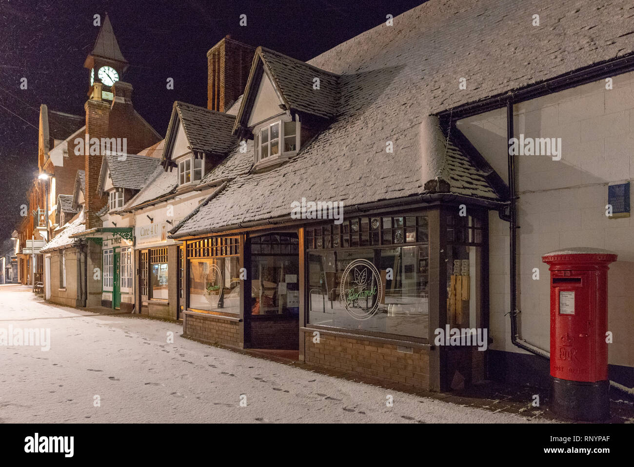 High Street in the New Forest village of Fordingbridge, Hampshire, UK after an evening winter snowfall. Stock Photo