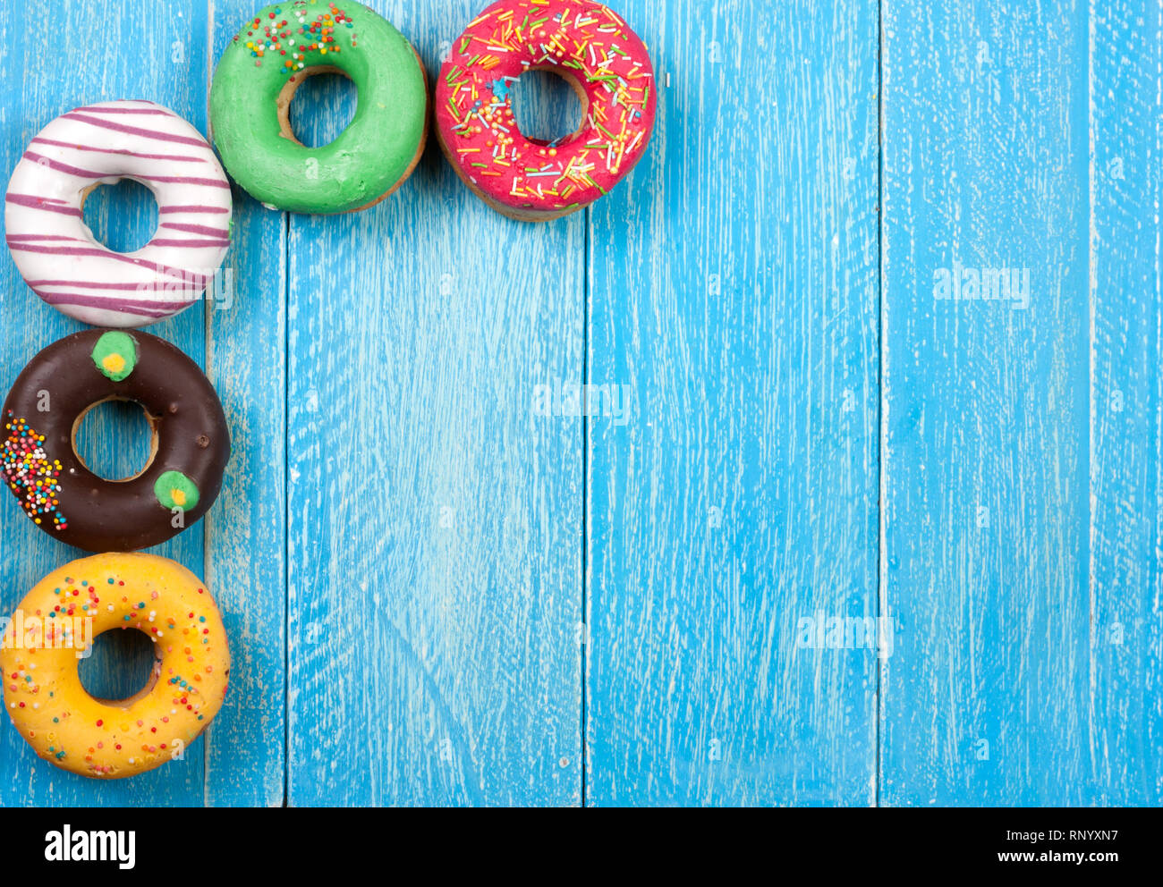 glazed donuts on a blue wooden background with copy space for your text ...