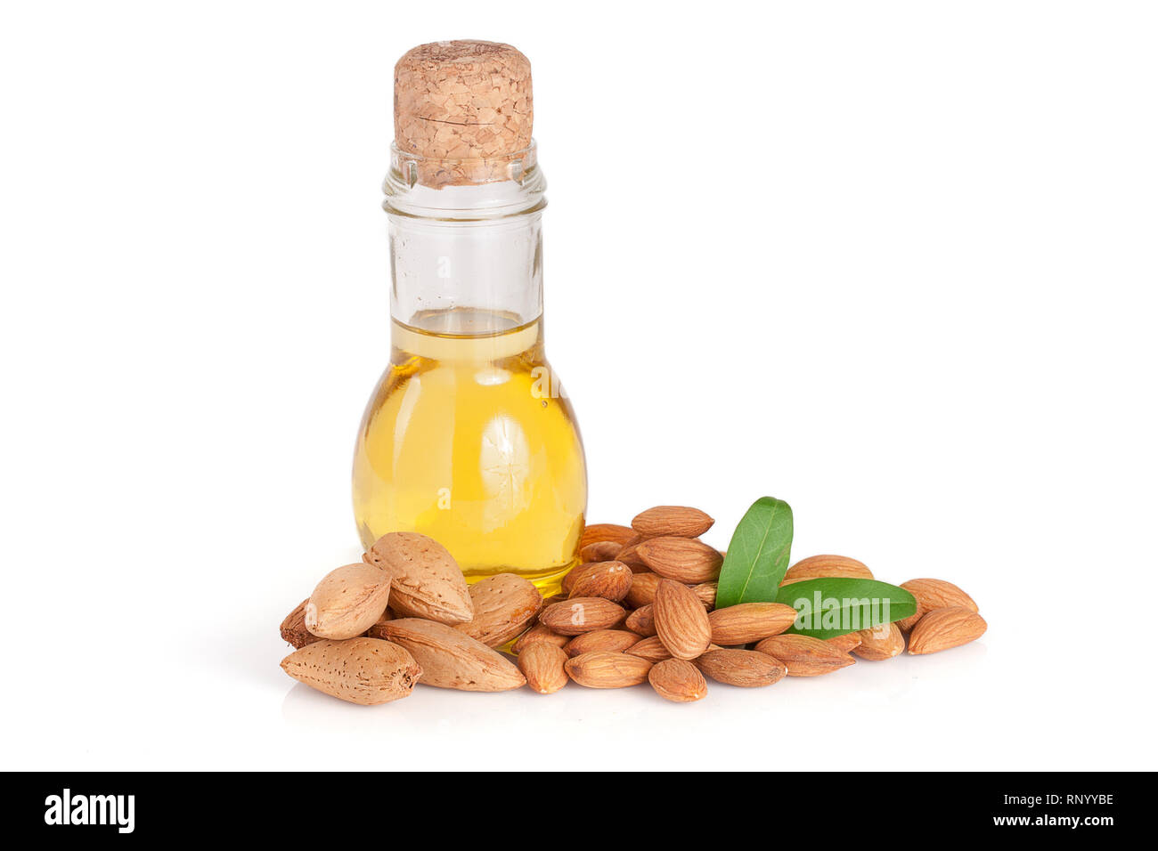 Bottle of almond oil and almonds with leaves isolated on white