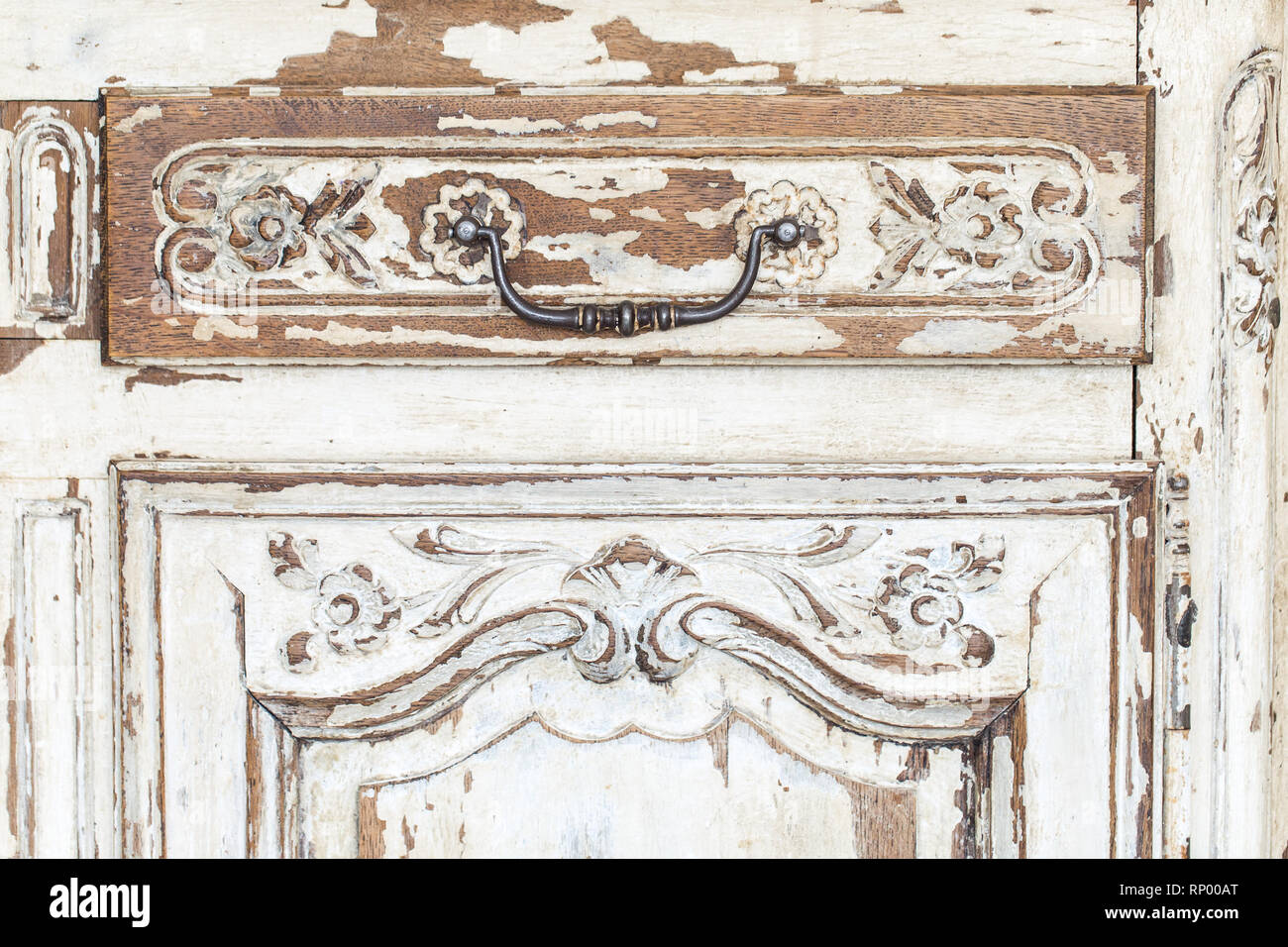Vintage chest of drawers with carving white color with fading and metal handle. Close-up. Selective focus Stock Photo
