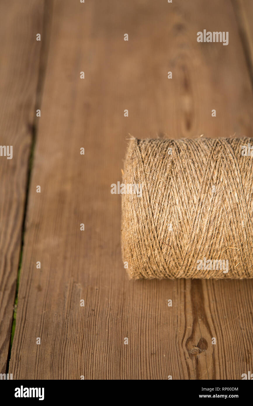 A roll of twine on a wooden background. Selelective focus. Close-up. Free space for text. Stock Photo
