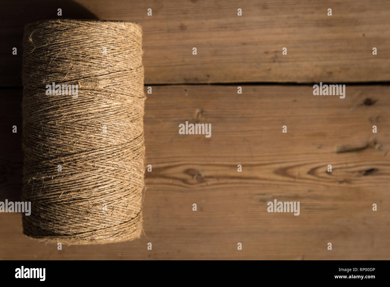 A roll of twine on a wooden background. Selelective focus. Close-up. Free space for text. Stock Photo