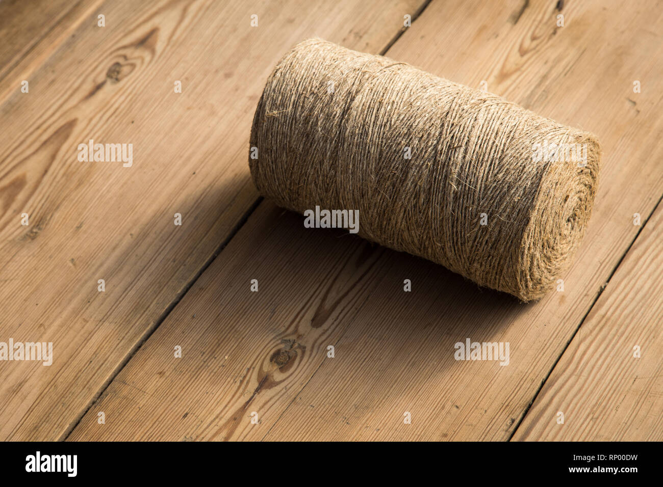 A roll of twine on a wooden background. Selelective focus. Close-up. Free space for text. Stock Photo