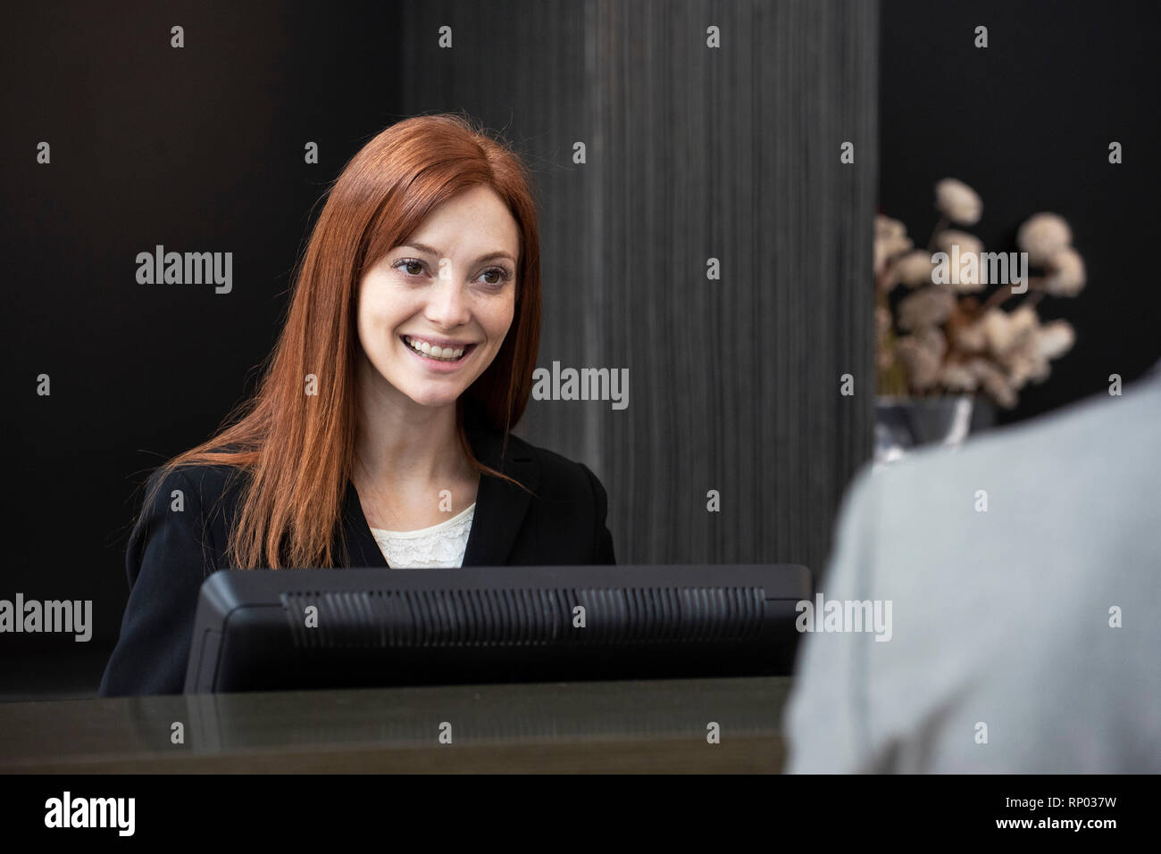 Female receptionist looking at businessman Stock Photo Alamy