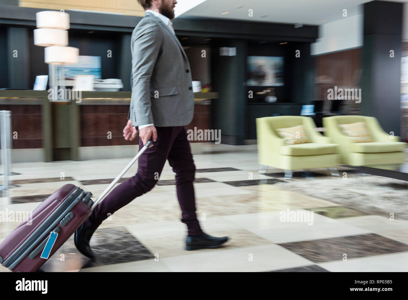 Businessman walking with wheeled luggage Stock Photo