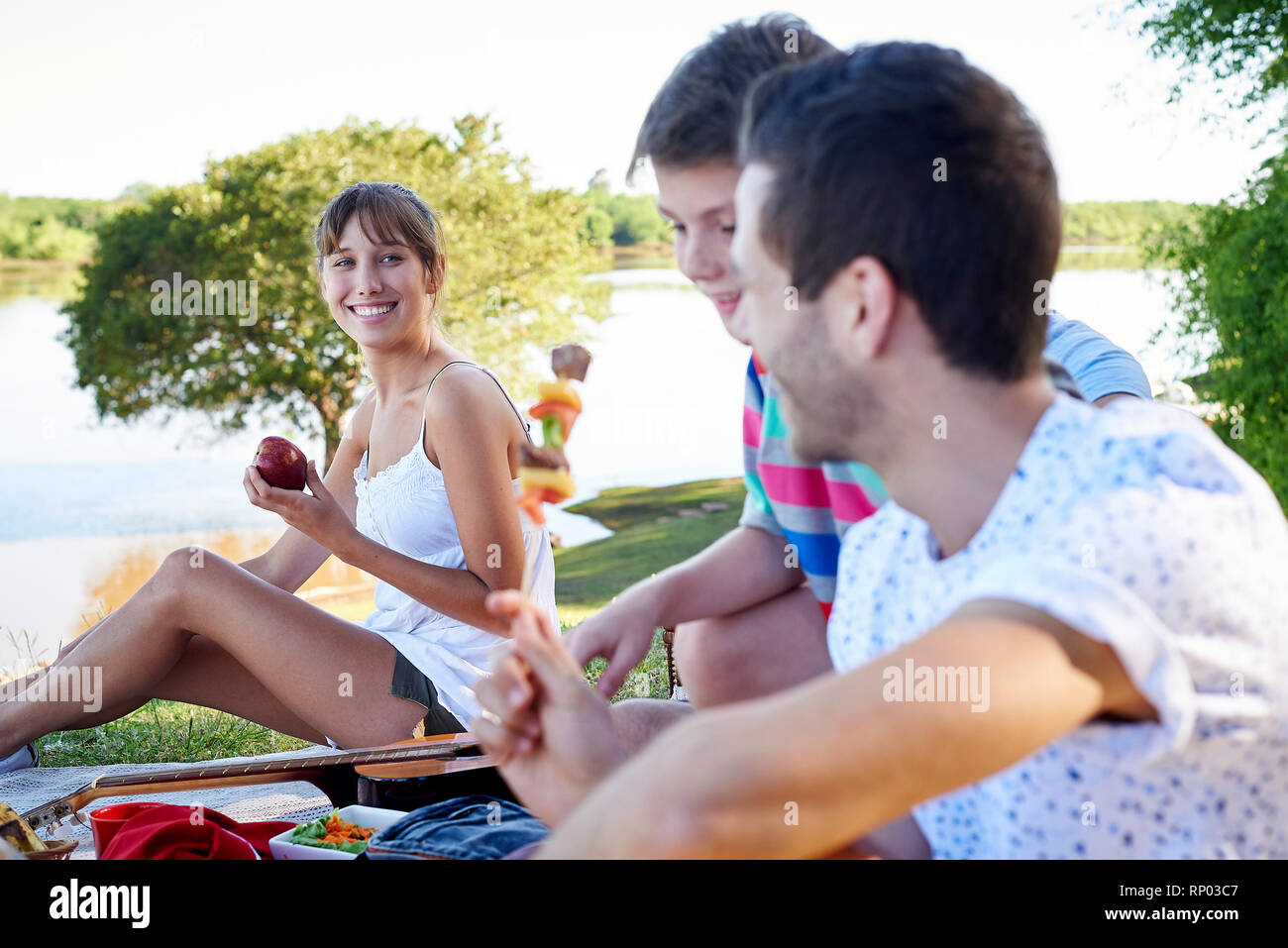 Family enjoying picnic near lake Stock Photo