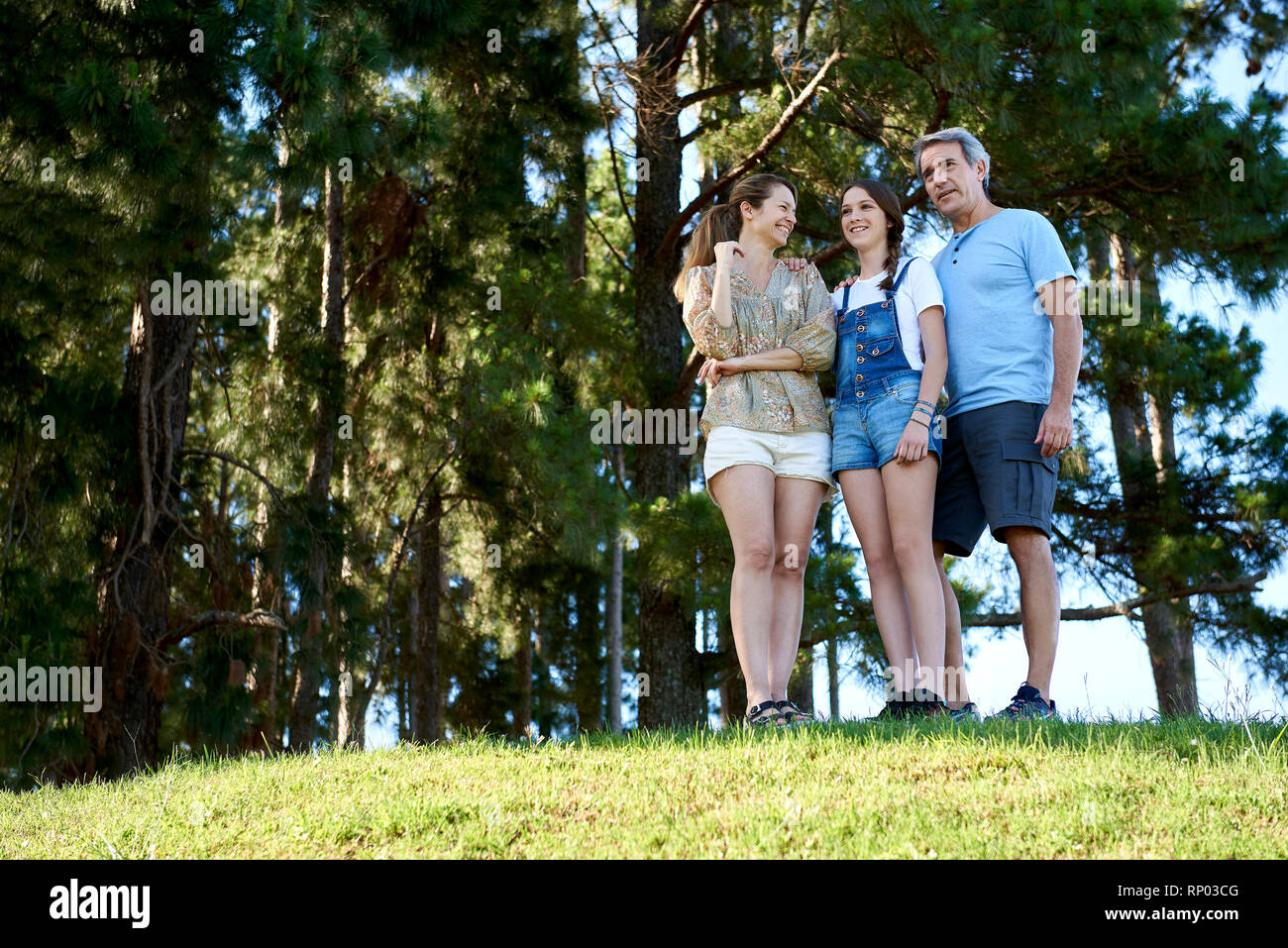 Family standing together on grassy hill Stock Photo