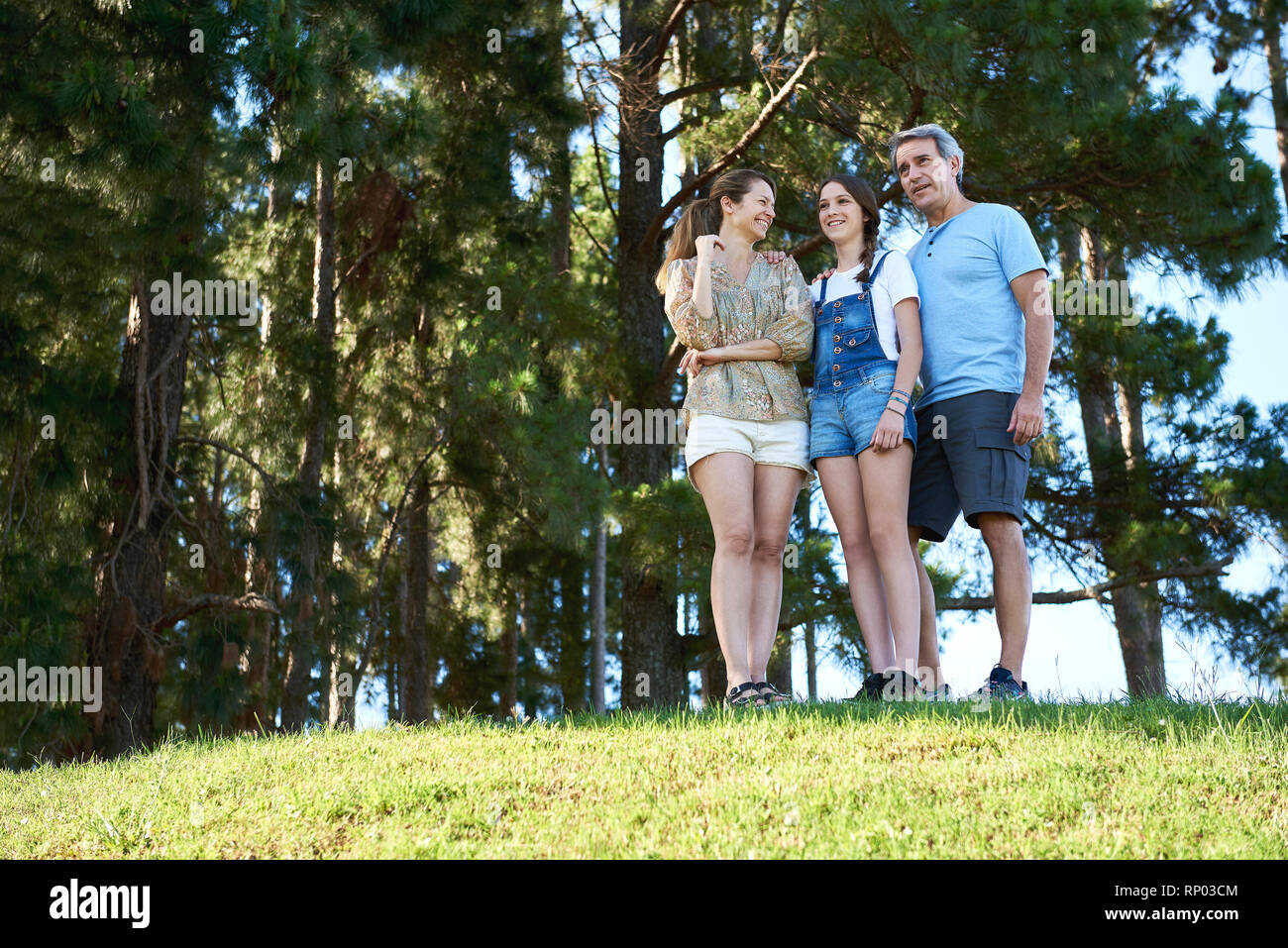 Family standing together on grassy hill Stock Photo