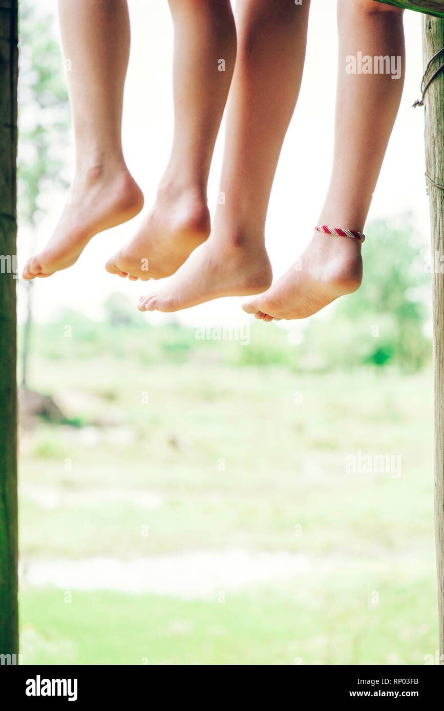 Low section of brother and sister relaxing in forest Stock Photo - Alamy