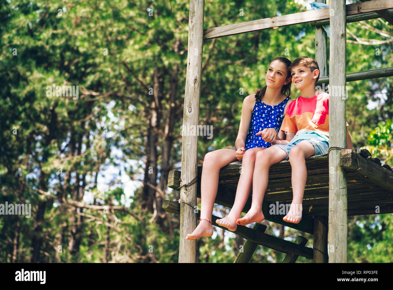 Brother and sister relaxing in forest Stock Photo - Alamy