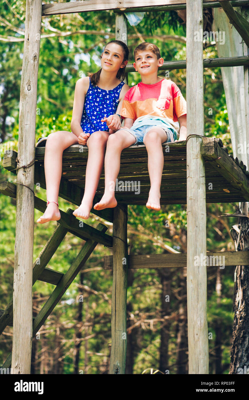 Brother and sister relaxing in forest Stock Photo - Alamy