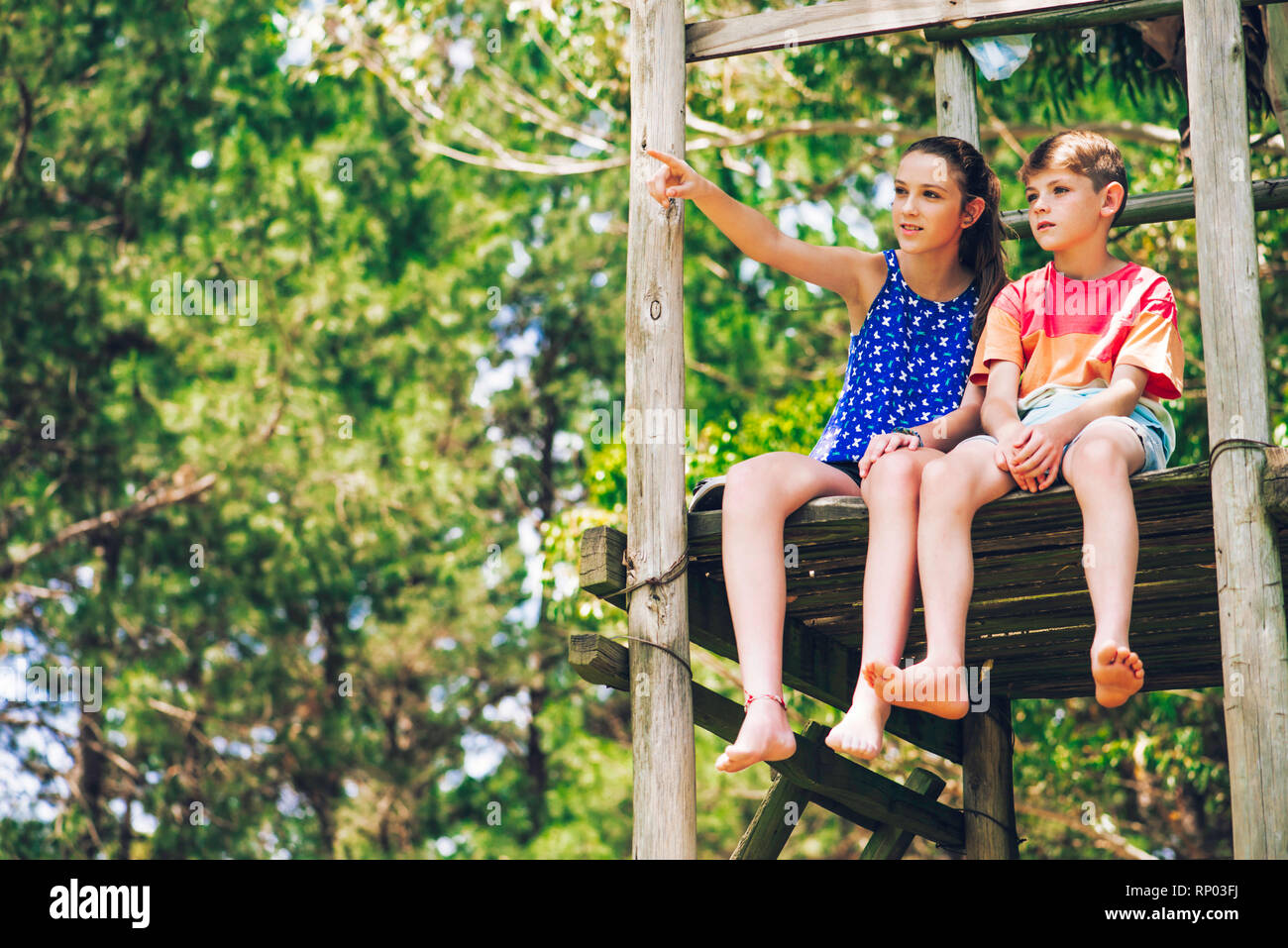 Brother and sister relaxing in forest Stock Photo - Alamy
