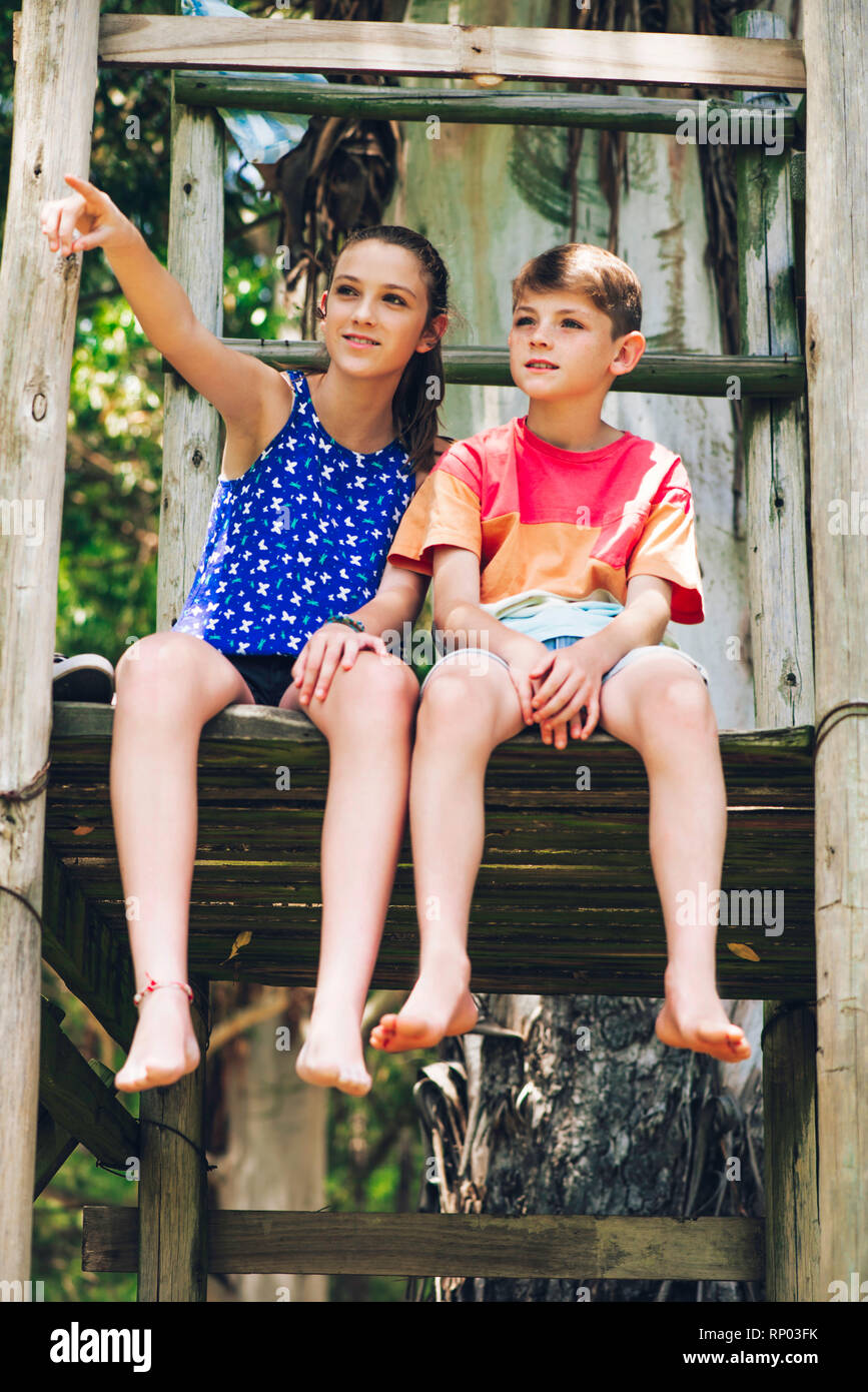 Brother and sister relaxing in forest Stock Photo - Alamy