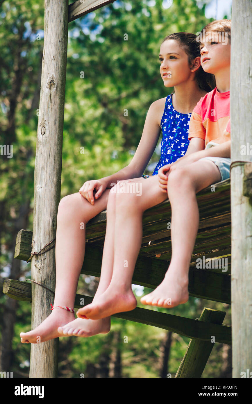 Brother and sister relaxing in forest Stock Photo - Alamy