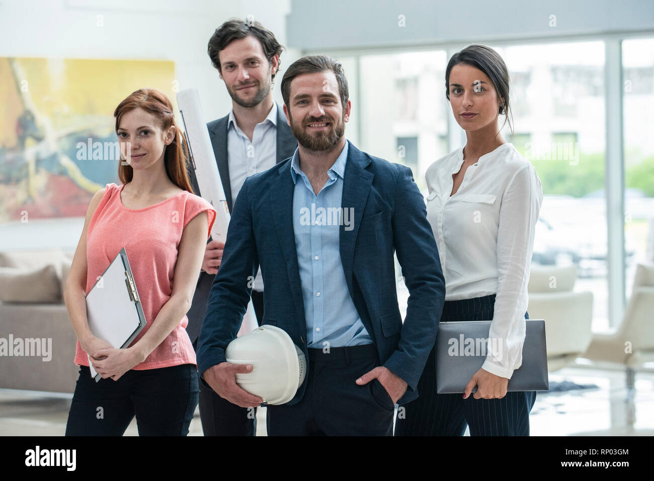 Smiling architects standing in hotel lobby Stock Photo