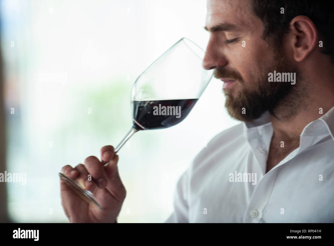 Close-up of mid adult man smelling red wine Stock Photo - Alamy