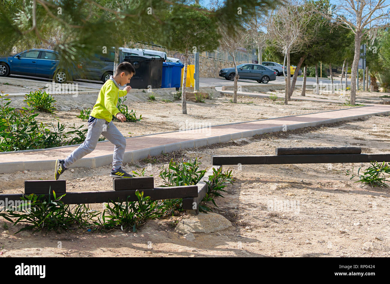 MURCIA / SPAIN - FEBRUARY 10 -2019: Little boy walking on a log in the park. child on the balance beam Stock Photo
