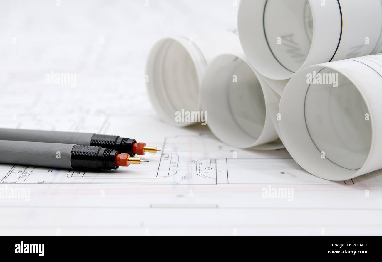 Rolled-up architectural plans and drawing utensils Stock Photo