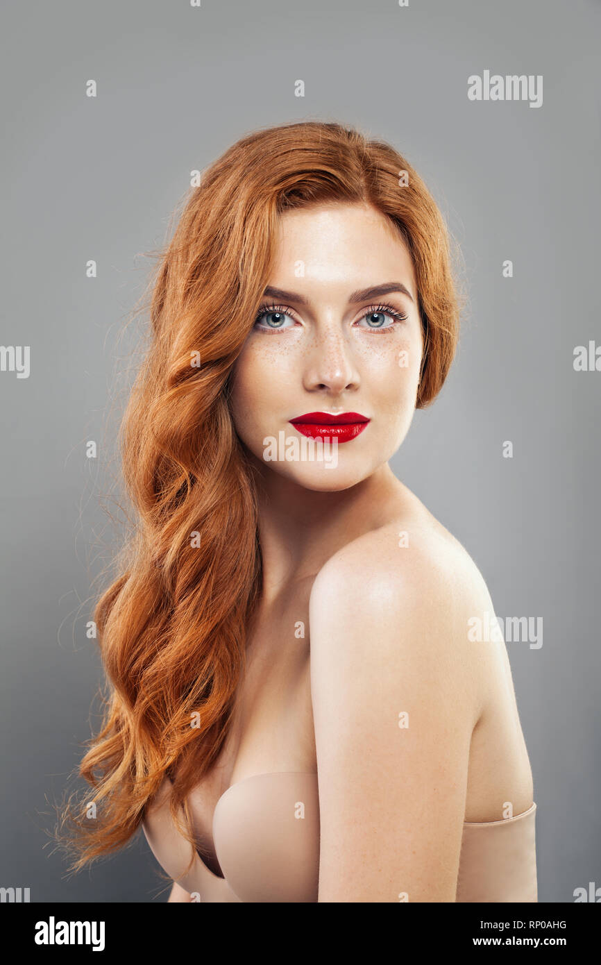 Tender redhead girl with healthy freckled skin. Caucasian woman model with ginger hair posing indoors Stock Photo