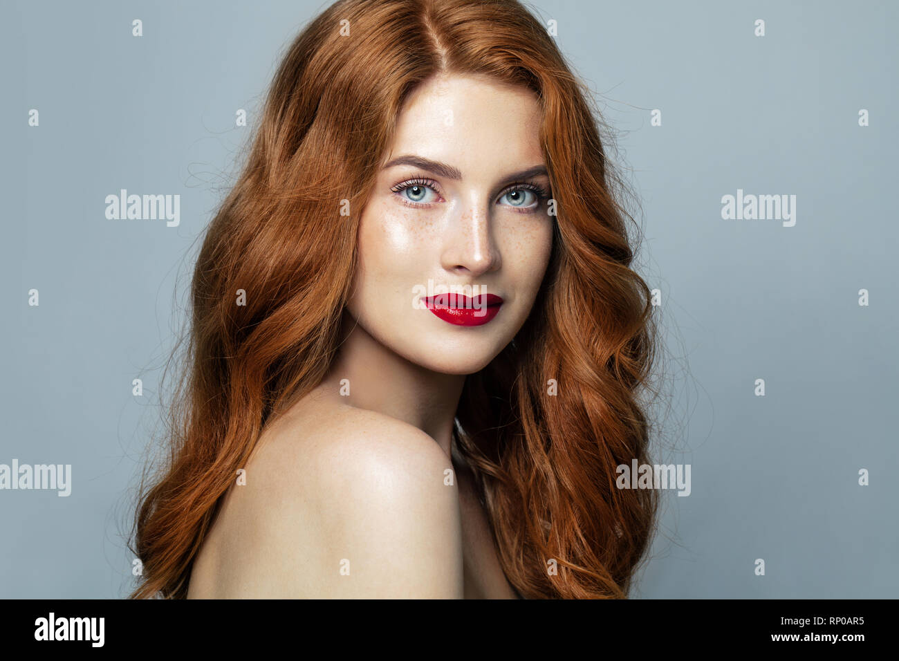 Pretty red haired woman studio portrait. Redhead girl smiling Stock Photo