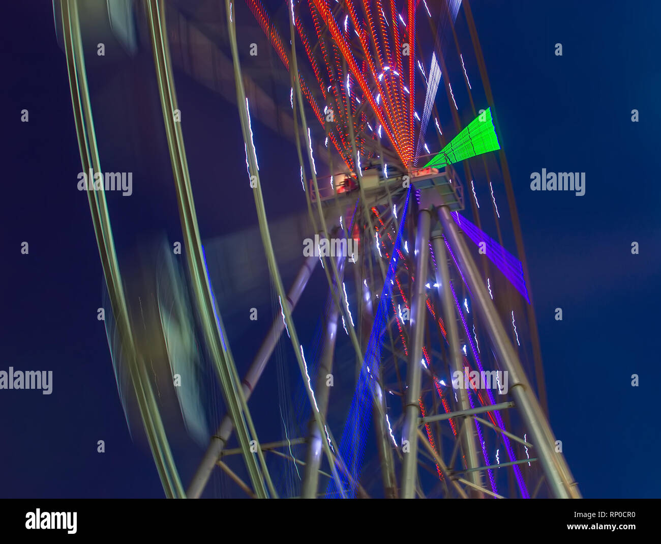 Carnival ride showing spinning ferris wheel in action long exposure