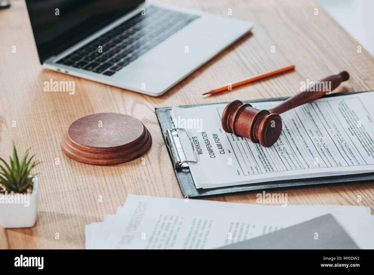 clipboard with compensation claim form and gavel lying over on the